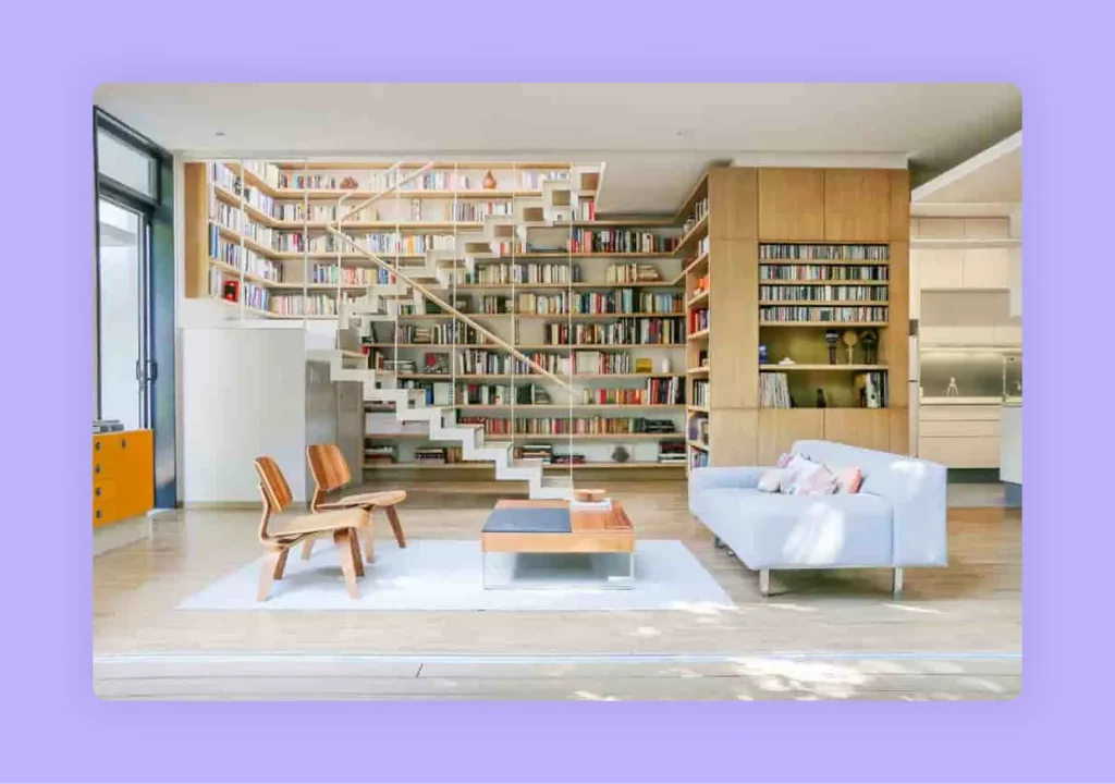 A home library featuring floor-to-ceiling bookshelves built around a modern staircase.