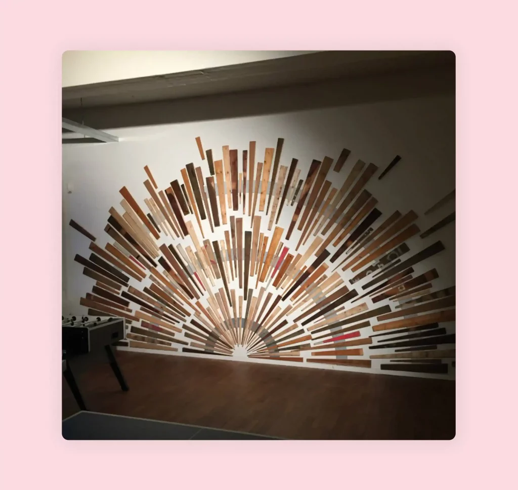 Wall art design in a sun shape made from recycled wood pieces.